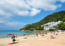 Scenic view of Nai Harn Beach with turquoise waters, sandy shores, and lush greenery