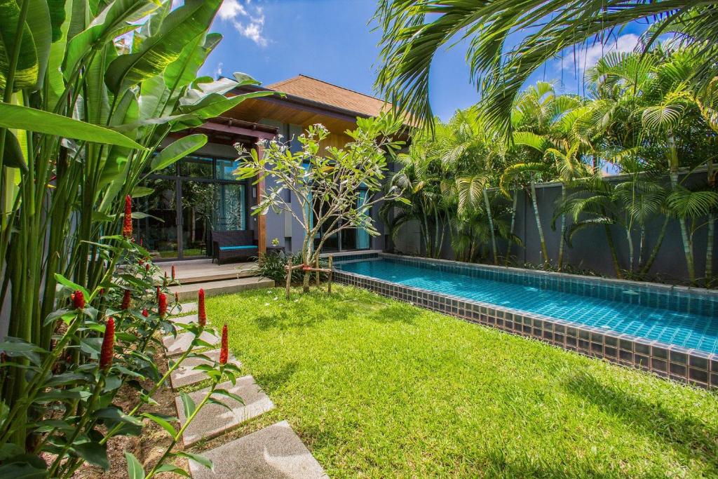 Exterior view of a private pool with garden at Villa Emere in Nai Harn Beach